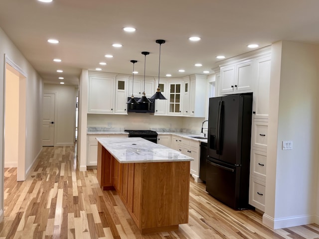 12 Windsor Rd, Ellsworth, ME 04605 - kitchen with black appliances, a sink, light wood-style flooring, a center island, and white cabinetry
