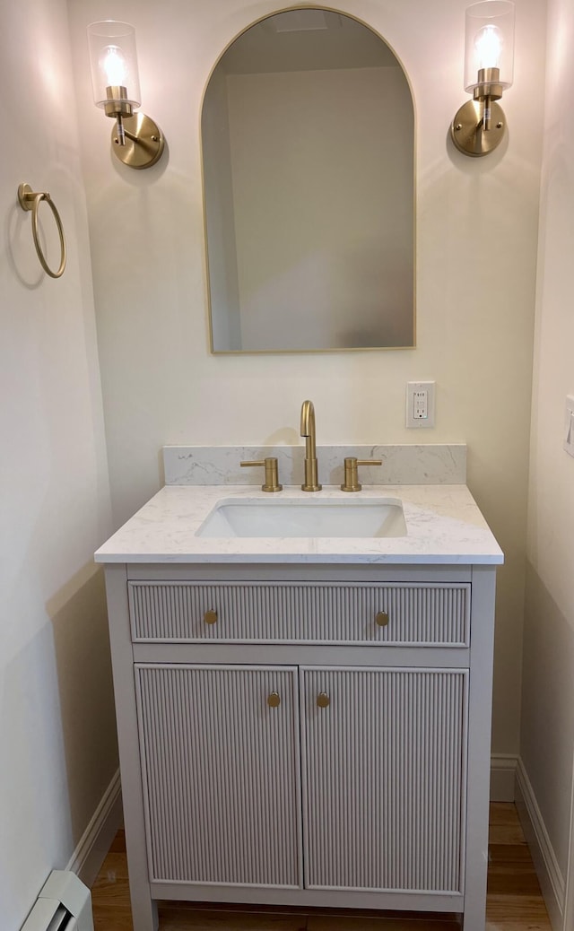 12 Windsor Rd, Ellsworth, ME 04605 - bathroom featuring baseboard heating, vanity, wood finished floors, and baseboards