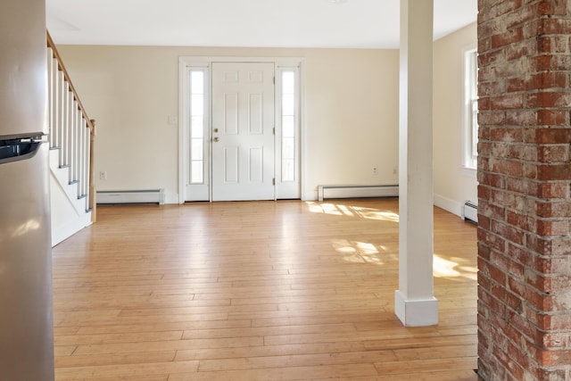 185 Depot Rd, Eliot, ME 03903 - foyer with a baseboard heating unit, stairway, light wood-style floors, plenty of natural light, and brick wall