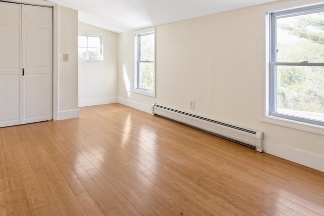 185 Depot Rd, Eliot, ME 03903 - unfurnished bedroom featuring a baseboard radiator, light wood-style flooring, vaulted ceiling, and baseboards