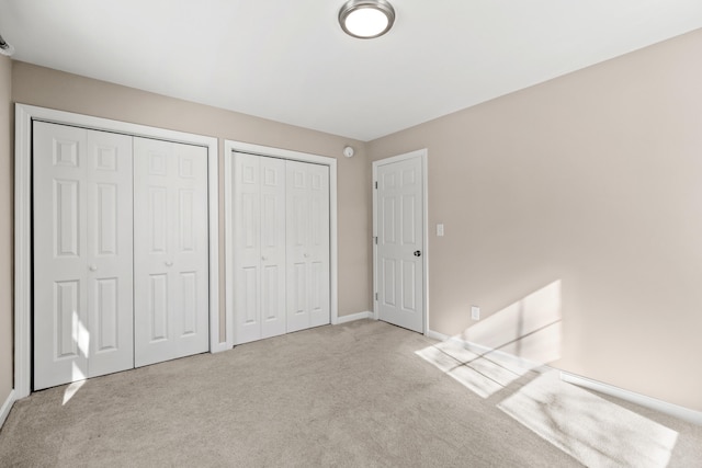 224 N St Unit 107, Saco, ME 04072 - unfurnished bedroom with multiple closets, carpet floors, and baseboards