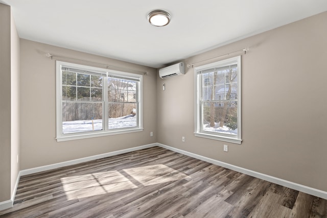 224 N St Unit 107, Saco, ME 04072 - unfurnished room with wood finished floors, baseboards, and an AC wall unit