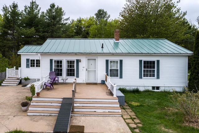31 Lakeview Dr, West Bath, ME 04530 - view of front of home with a chimney, metal roof, a deck, and a front lawn
