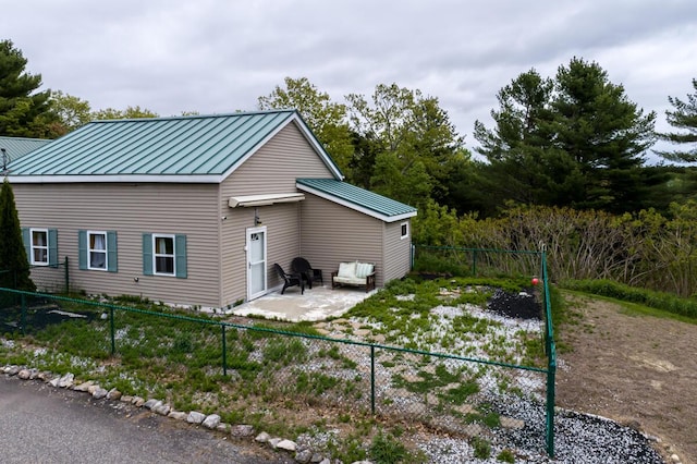31 Lakeview Dr, West Bath, ME 04530 - view of side of home featuring a standing seam roof, metal roof, a patio, and a fenced backyard