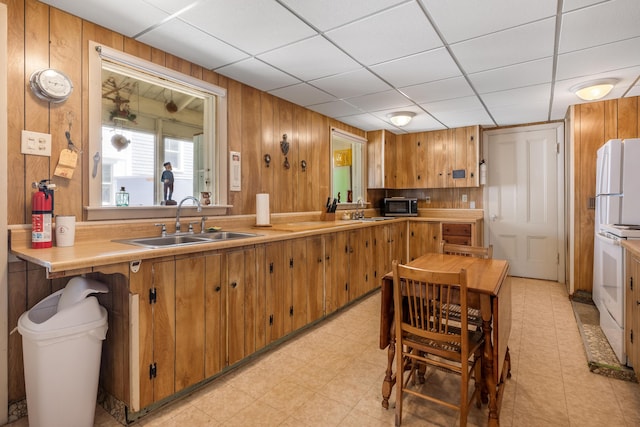 27 Ocean Ave Extension Unit 2, York, ME 03909 - kitchen featuring a sink, brown cabinets, wooden walls, white appliances, and light countertops