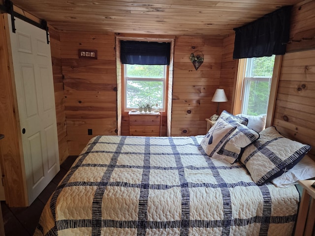 101 Brooks & Dunn Road, Otis, ME 04605 - bedroom with wood walls, wooden ceiling, and a barn door