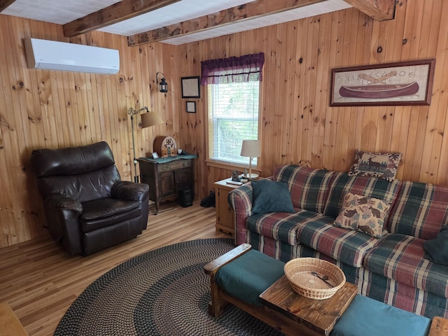 101 Brooks & Dunn Road, Otis, ME 04605 - living room with a wall mounted AC, beam ceiling, wood finished floors, and wooden walls