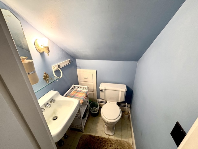 187 Maine Ave, Millinocket, ME 04462 - bathroom with vaulted ceiling, toilet, a sink, and tile patterned flooring