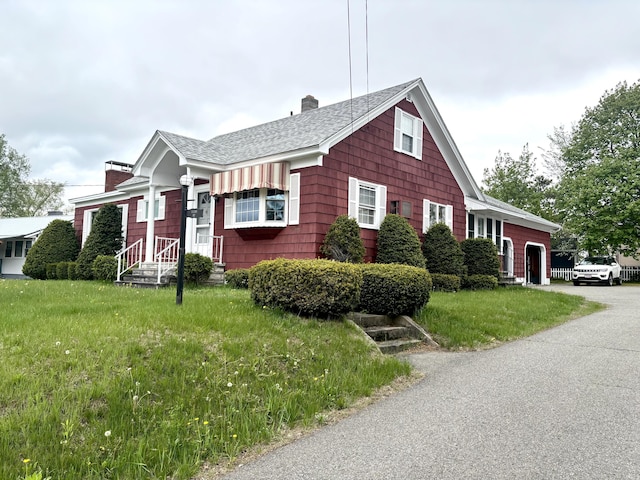 187 Maine Ave, Millinocket, ME 04462 - view of front of house with a chimney, a shingled roof, concrete driveway, and a front yard