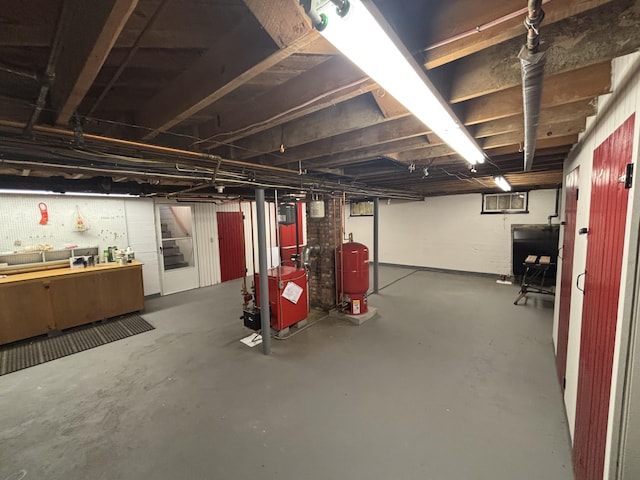187 Maine Ave, Millinocket, ME 04462 - unfinished basement featuring a water pressure tank, a workshop area, and a heating unit