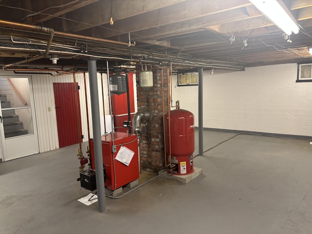 187 Maine Ave, Millinocket, ME 04462 - unfinished basement featuring a water pressure tank, stairs, and a heating unit