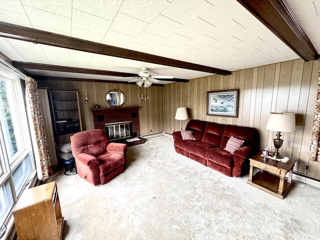 187 Maine Ave, Millinocket, ME 04462 - living area featuring beamed ceiling, carpet, a ceiling fan, wood walls, and a brick fireplace