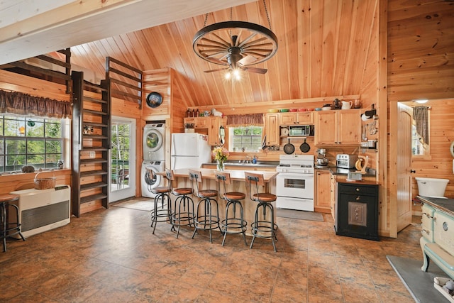 30 Bassett Ln, Moscow, ME 04920 - kitchen featuring white appliances, stacked washer / drying machine, wood walls, plenty of natural light, and wooden ceiling