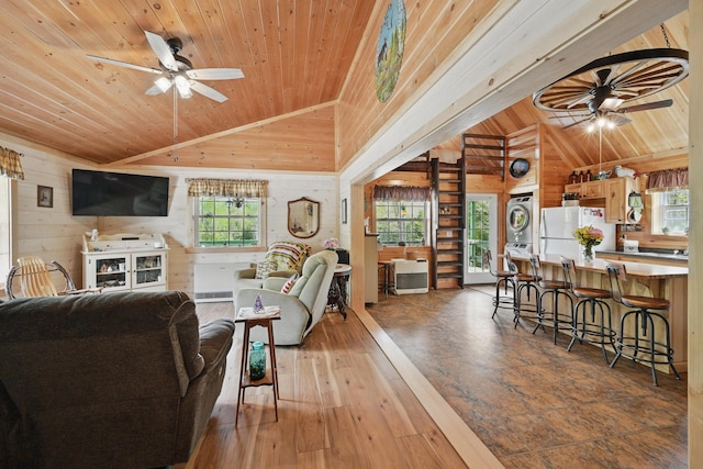 30 Bassett Ln, Moscow, ME 04920 - living area featuring estacked washer and dryer, wood ceiling, wood walls, lofted ceiling, and ceiling fan