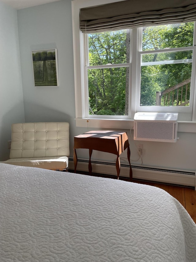 67 Pascal Ave, Rockport, ME 04856 - bedroom with a baseboard radiator, a wall unit AC, and wood finished floors