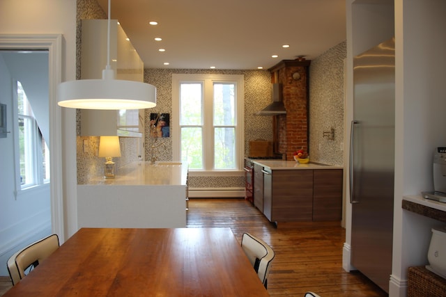 67 Pascal Ave, Rockport, ME 04856 - kitchen featuring appliances with stainless steel finishes, wall chimney range hood, a baseboard heating unit, dark wood-type flooring, and light countertops
