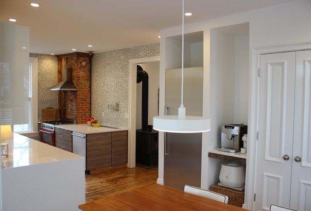 67 Pascal Ave, Rockport, ME 04856 - kitchen featuring wall chimney exhaust hood, range with gas stovetop, stainless steel dishwasher, light wood finished floors, and light countertops