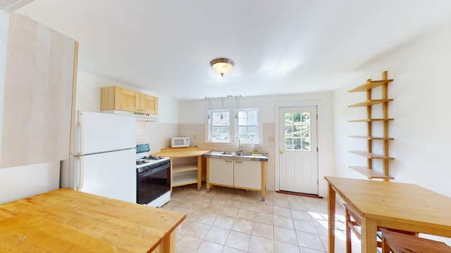 103 Water St, Machias, ME 04654 - kitchen with white appliances, under cabinet range hood, light tile patterned floors, tasteful backsplash, and a sink