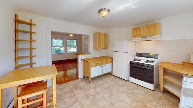 103 Water St, Machias, ME 04654 - kitchen with white appliances, under cabinet range hood, tasteful backsplash, and light brown cabinetry