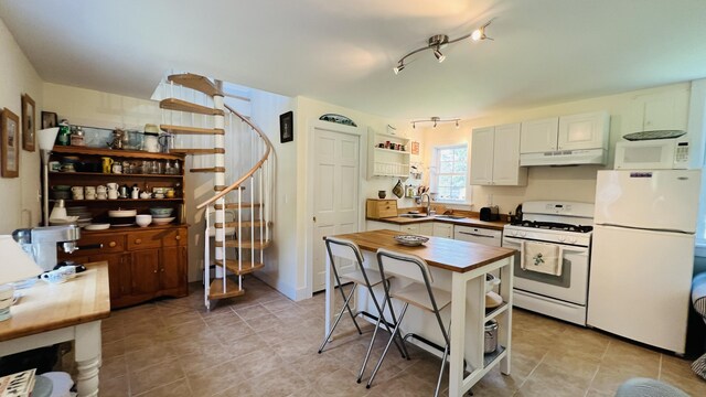 103 Water St, Machias, ME 04654 - kitchen with white appliances, open shelves, under cabinet range hood, wood counters, and light tile patterned floors