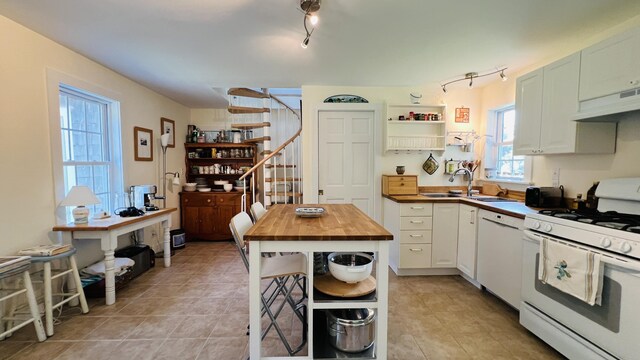 103 Water St, Machias, ME 04654 - kitchen with white appliances, under cabinet range hood, a sink, butcher block countertops, and open shelves