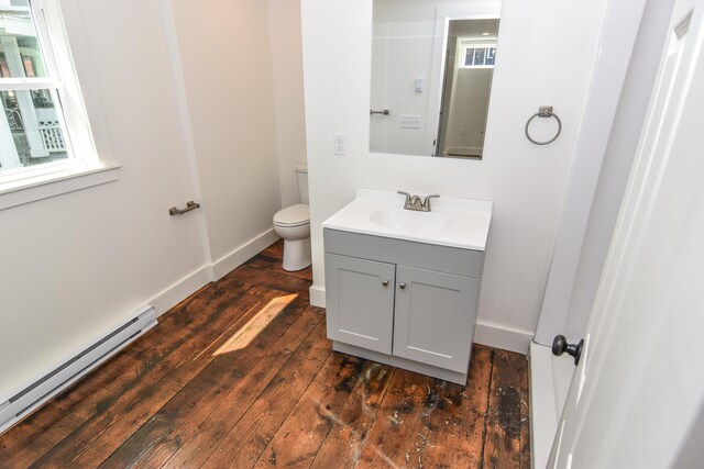 33 Main St, Cornish, ME 04020 - half bath with a baseboard radiator, vanity, hardwood / wood-style floors, toilet, and baseboards