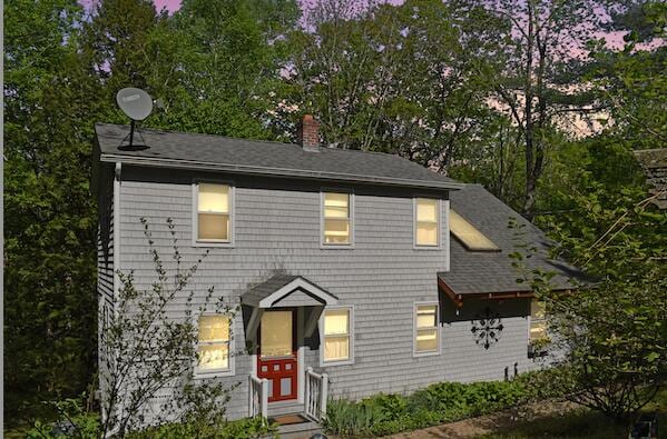 217 Jackson Rd, Monroe, ME 04951 - view of front of house featuring a chimney, view of scattered trees, and a shingled roof