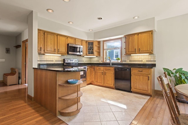 43 W Lynne Ave, Portland, ME 04103 - kitchen featuring open shelves, stainless steel appliances, dark countertops, decorative backsplash, and brown cabinetry