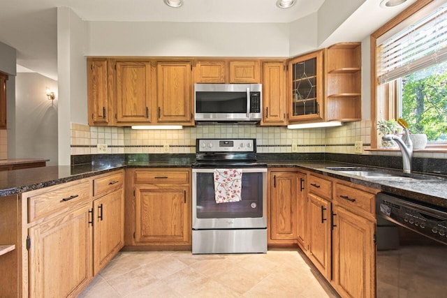 43 W Lynne Ave, Portland, ME 04103 - kitchen with stainless steel appliances, open shelves, a sink, dark stone countertops, and tasteful backsplash