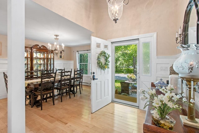 12 Kimberly Ct Unit 1, Portland, ME 04103 - entryway with a chandelier, a decorative wall, wainscoting, light wood-style flooring, and a towering ceiling