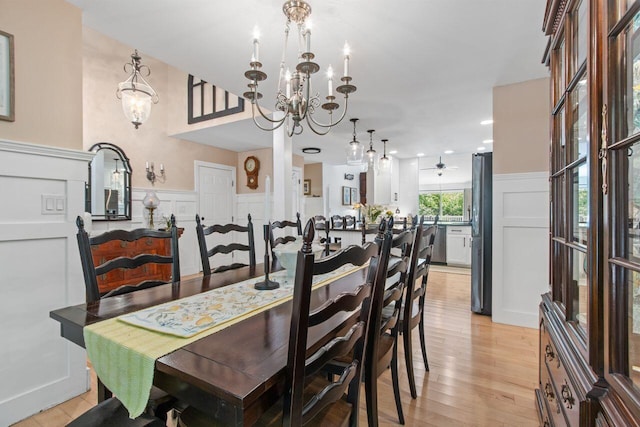 12 Kimberly Ct Unit 1, Portland, ME 04103 - dining area featuring a chandelier, a decorative wall, wainscoting, ceiling fan, and light wood-style flooring