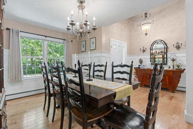 12 Kimberly Ct Unit 1, Portland, ME 04103 - dining area with a chandelier, wainscoting, light wood-style floors, a baseboard radiator, and a decorative wall