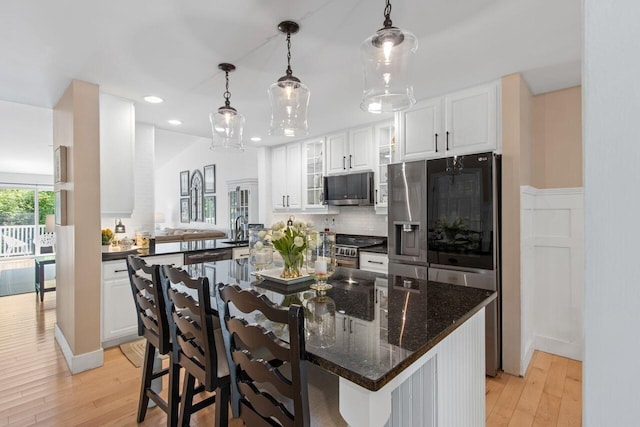 12 Kimberly Ct Unit 1, Portland, ME 04103 - kitchen featuring stainless steel appliances, white cabinets, recessed lighting, light wood finished floors, and a kitchen breakfast bar