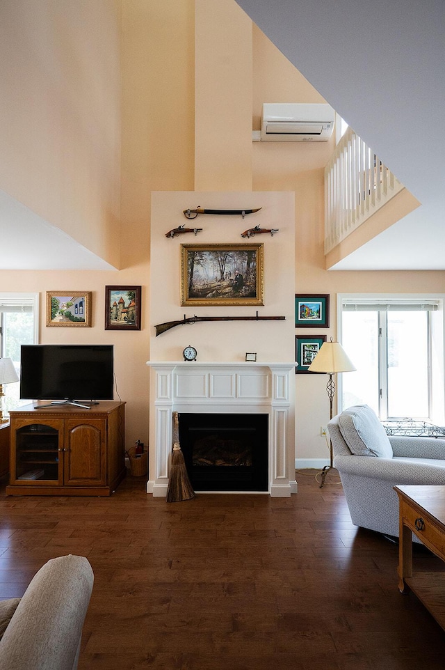 7 Goodridge Dr Unit 7, Naples, ME 04055 - living area with a wall mounted AC, a high ceiling, wood finished floors, a fireplace, and baseboards