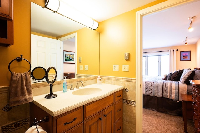 7 Goodridge Dr Unit 7, Naples, ME 04055 - ensuite bathroom featuring vanity, a wainscoted wall, and tile walls