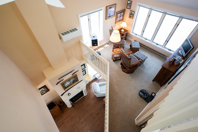 7 Goodridge Dr Unit 7, Naples, ME 04055 - living room featuring a fireplace, an AC wall unit, a towering ceiling, and baseboards