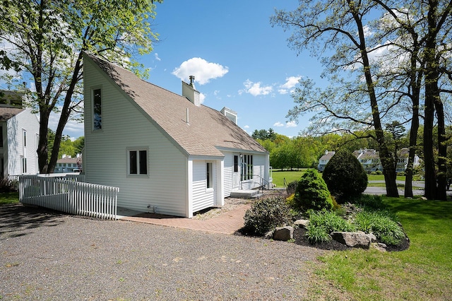 7 Goodridge Dr Unit 7, Naples, ME 04055 - view of home's exterior featuring a chimney, roof with shingles, and a yard