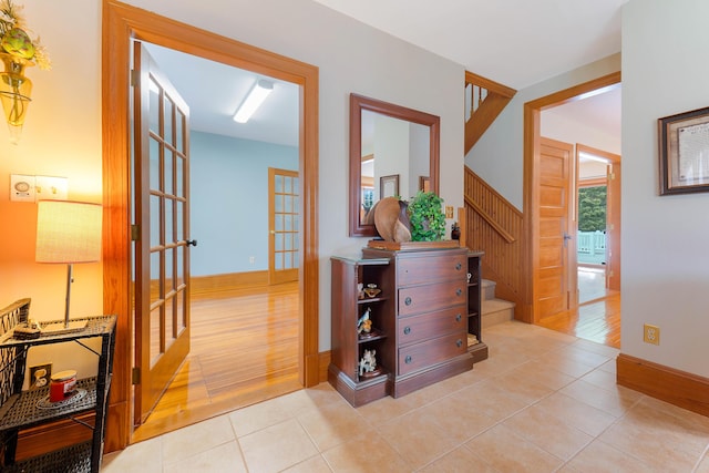 96 Grove St, Lewiston, ME 04240 - hall featuring french doors, stairway, light tile patterned floors, and baseboards