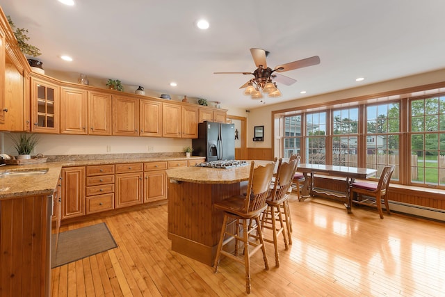 96 Grove St, Lewiston, ME 04240 - kitchen featuring black fridge with ice dispenser, a sink, a kitchen island, a ceiling fan, and a kitchen breakfast bar
