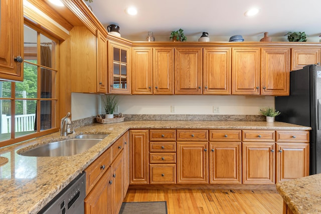 96 Grove St, Lewiston, ME 04240 - kitchen featuring a sink, brown cabinetry, glass insert cabinets, light wood finished floors, and freestanding refrigerator