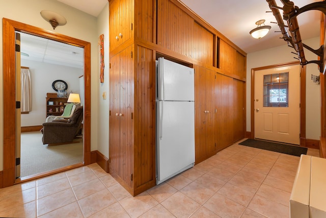 96 Grove St, Lewiston, ME 04240 - kitchen featuring freestanding refrigerator, light tile patterned floors, baseboards, and brown cabinets