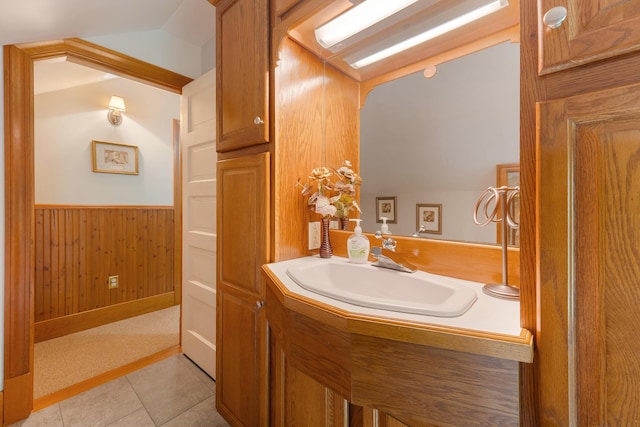 96 Grove St, Lewiston, ME 04240 - bathroom featuring wainscoting, wooden walls, vanity, tile patterned floors, and lofted ceiling