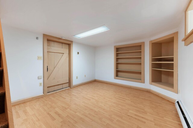 96 Grove St, Lewiston, ME 04240 - empty room featuring a baseboard radiator, built in features, wood finished floors, and baseboards
