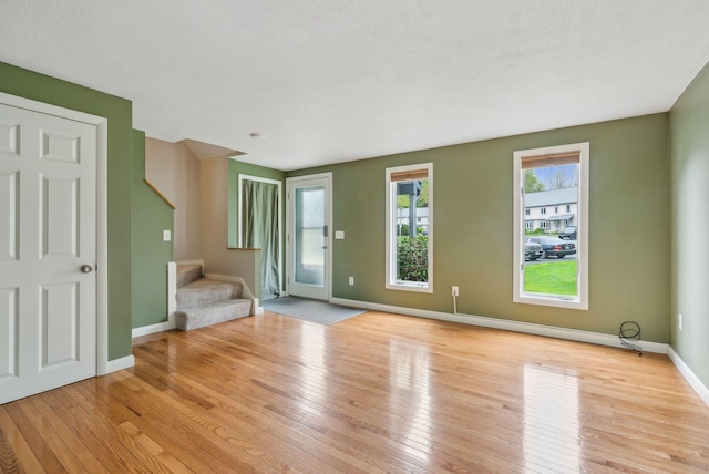 17 Graham Rd Unit 17, Westbrook, ME 04092 - unfurnished living room featuring stairs, hardwood / wood-style floors, and baseboards