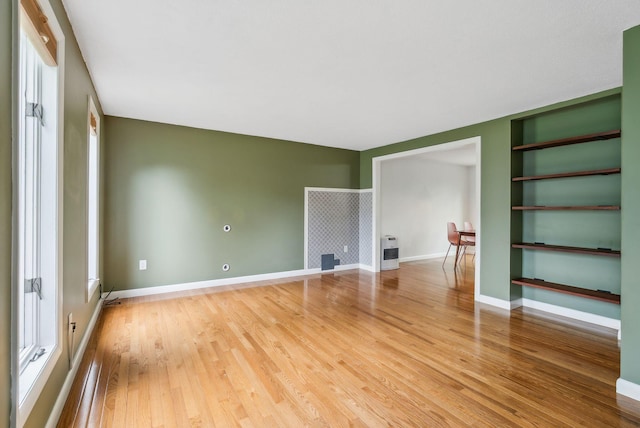 17 Graham Rd Unit 17, Westbrook, ME 04092 - empty room with light wood-style floors, built in shelves, baseboards, and heating unit
