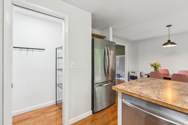 17 Graham Rd Unit 17, Westbrook, ME 04092 - kitchen with stainless steel appliances, light wood-type flooring, baseboards, and decorative light fixtures