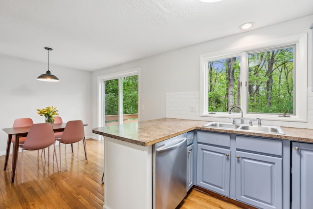 17 Graham Rd Unit 17, Westbrook, ME 04092 - kitchen featuring dishwasher, a sink, light wood-type flooring, backsplash, and a peninsula