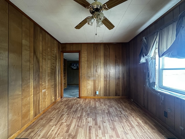 29 Exchange St, Presque Isle, ME 04769 - empty room featuring ceiling fan, light wood-type flooring, wood walls, and baseboards
