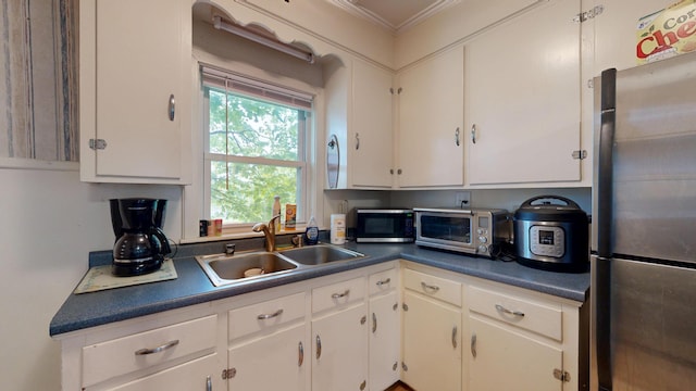 17 Wellman St, Lewiston, ME 04240 - kitchen featuring stainless steel appliances, a sink, crown molding, dark countertops, and white cabinetry