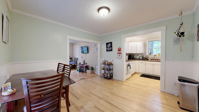 17 Wellman St, Lewiston, ME 04240 - dining area with wainscoting, light wood finished floors, and crown molding
